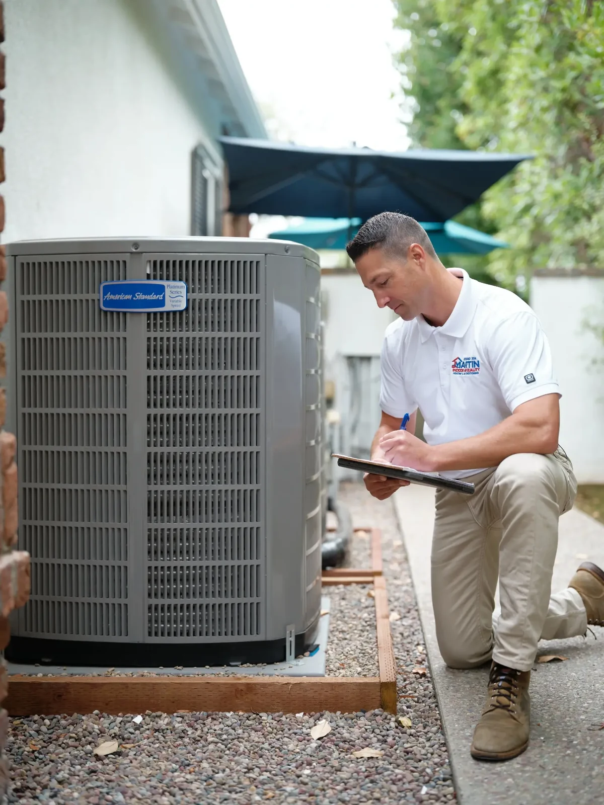 HVAC technician assessing an outdoor residential air conditioning system